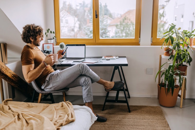 Male homeowner sitting at desk reviewing heat pump efficiency information.